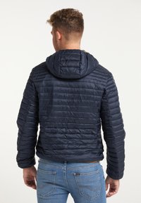 Giacca imbottita blu navy con cappuccio, caratterizzata da un design aderente, una texture liscia e sezioni imbottite orizzontali.
