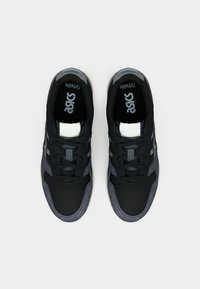 Svarta och grå sportskor med ovandel i mesh och mocka, med rund tå, snörning och en vit detalj på tungan.