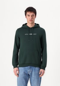 Dunkelgrüner Hoodie mit einer vorderen Kängurutasche, Kapuze mit Kordelzug und weißem japanischem Text, der auf der Brust gedruckt ist. Ribbed Bündchen und Saum.