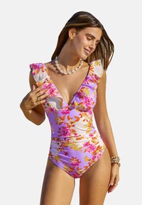 Maillot de bain à fleurs en violet clair avec des bretelles en volants, décoré de fleurs orange et roses sur un tissu lisse.