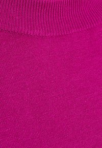 Fuchsia Strickstoff mit einem feinen, strukturierten Aussehen. Der gerippte Bund oben fügt dem Gesamtdesign Details hinzu.