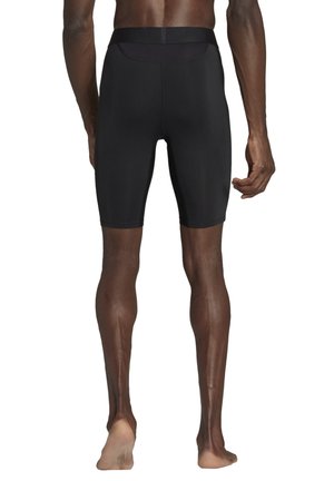 Schwarze Sportshorts mit tailliertem Schnitt, aus glattem, dehnbarem Material, mit nahtlosem Bund und einer Länge bis zur Mitte des Oberschenkels.