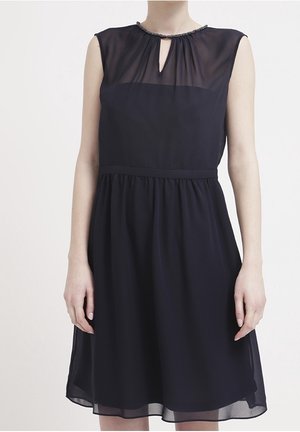 Marineblaues Kleid aus transparentem Stoff, mit Schlüsselloch-Ausschnitt und Perlendetails. Eng anliegender Bund mit einem ausgestellten Rock, der über den Knien endet.