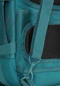 Turkusowy plecak z teksturowanej tkaniny, siateczkowym panelem i taśmami. Posiada zapięcie na haczyk oraz wzmocnione szwy dla większej trwałości.