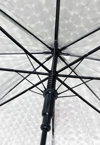 Transparent umbrella with a black metal frame, featuring a textured, checkered canopy and a central, adjustable spring mechanism.