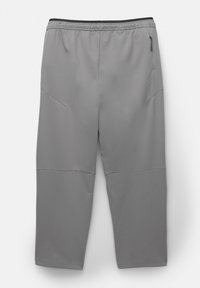 Grå træningsbukser med en glat tekstur, elastisk talje og sidelomme med lynlås. Har tapered ben og sømdetaljer.
