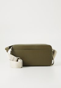 Olive green rectangular crossbody bag with a smooth finish, featuring a beige adjustable strap and a zipper closure. Minimalist design.