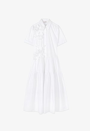 Weißes Midi-Kleid mit kurzen Ärmeln, gestufter Rockpartie, Kragen und floralen Applikationen auf der linken Brust und Schulter.