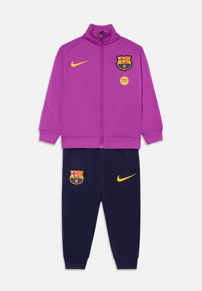 Barns tvådelade sportträningsoverall med lila zip-up jacka och marinblå byxor, med FC Barcelona och Nike-loggor i gult.
