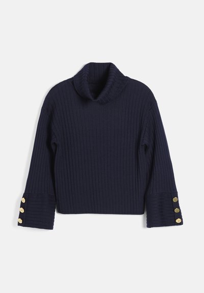 Pull côtelé bleu marine à manches longues avec un col roulé plié et des boutons dorés sur les larges poignets.