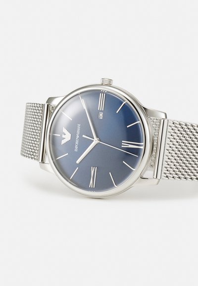 Silbernes Mesh-Armband-Uhr mit einem dunkelblauen Zifferblatt, römischen Ziffern, Datumsfenster und einem Emporio Armani-Logo auf dem Ziffernblatt.