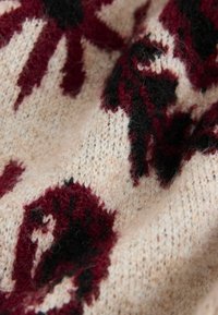 Kootud kangas, millel on kreemjas taust, burgundia lillemustrid ja mustad aktsendid. Tekstuur näeb välja pehme ja veidi udune.