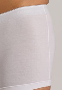 Bílé bavlněné boxerky s hladkou texturou, přiléhavým střihem a měkkým pasem s jemným brandingem na vrchu.