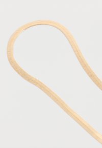 Guld-tone metal kædedyse med et fladt, glat design og fiskebensmønster, der viser en fleksibel, konisk form.