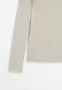 Manche de pull long beige en tricot et côté visibles sur fond blanc, montrant un tissu à texture fine et un ourlet droit.