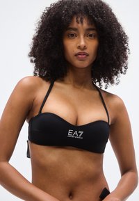 Μαύρο μπικίνι τοπ bandeau με λεία υφή, ρυθμιζόμενες τιράντες και λευκό λογότυπο "EA7 Emporio Armani" στο μπροστινό μέρος.