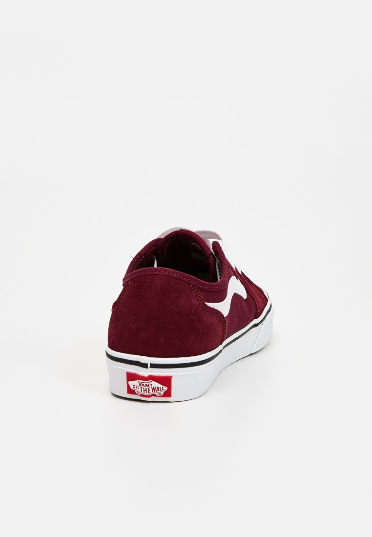 Baskets en daim bordeaux avec des accents blancs. Design basse, bout rond et semelle en caoutchouc. Présente le logo Vans sur le talon.