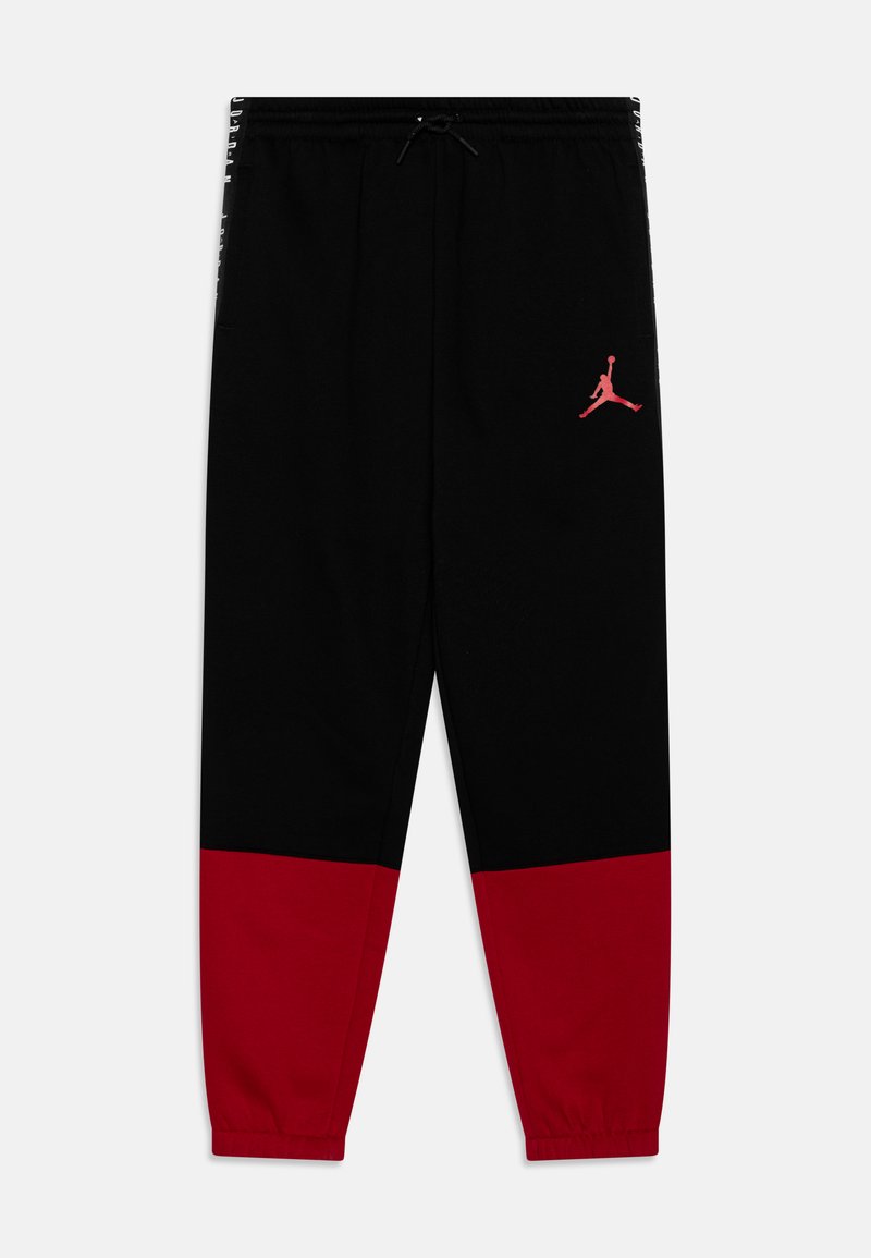 Czarne dresy z czerwonym dolnym panelem, elastycznymi mankietami i ściągaczem w pasie. Na udzie znajduje się czerwone logo Jumpman.