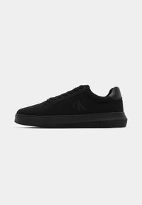Zwarte sneaker met een gladde stoffen bovenkant, ronde neus, vetersluiting en een geribbelde rubberen zool. Heeft een subtiel logo aan de zijkant.