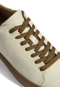 Weiße Sneaker aus Leder mit strukturiertem Obermaterial, braunen Schnürsenkeln und runden Ösen. Verfügt über eine flache Sohle und gestickte Akzente.