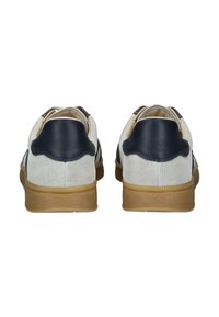 Pair of white and navy suede sneakers with gum rubber soles viewed from the back on a white background.