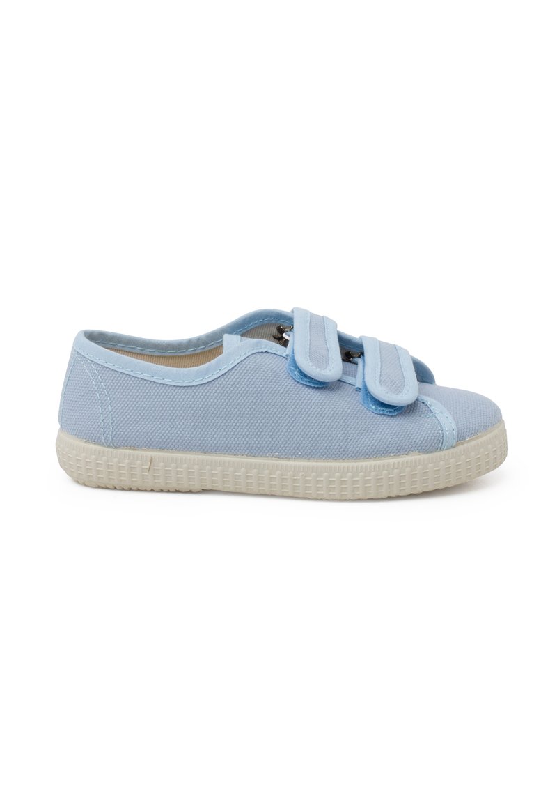 Chaussure en toile bleu clair avec deux bandes Velcro, bout arrondi et semelle en caoutchouc blanc texturé. Design simple, silhouette basse.