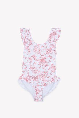 One-piece swimsuit in white with red floral print. Features ruffled shoulder straps and a ruffled trim at the leg openings. Soft material.