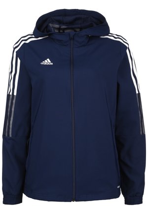 Laivastonsininen Adidas-huppari, jossa on täysipitkä vetoketju edessä, valkoiset kolmiraitaiset yksityiskohdat hihoissa ja verkkokangaspaneelit yläkäsivarsissa.