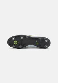 Nike soccer cleat sole with black rubber, six metal studs, a green central plate, and a subtle gray and yellow accent on the upper edge.