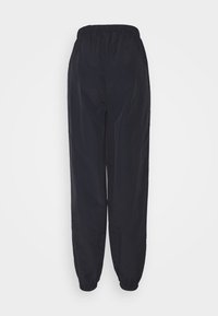Black, lightweight, elastic-waist pants with a loose fit, featuring elastic cuffs and a smooth texture, designed for comfort and ease of movement.