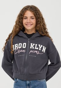 Ciemnoszara bluza z kapturem na zamek z kieszenią kangurką, z białym napisem "BROOKLYN Champions Athletic Division" i kapturem ze sznurkiem.