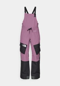 Lillat veekindlad üleüldised püksid mustade detailidega, reguleeritavad rihmad, mitme taskuga ja logo detail vasakul küljel.