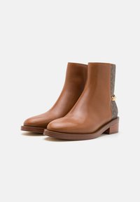 Brown leather ankle boots with a smooth finish, a low stacked heel, and patterned fabric accents on the sides. Gold hardware detail at the back.