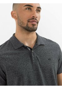 Mørk grå polo t-shirt med tekstureret stof, korte ærmer og krave. Har et lille logo på venstre bryst og en knapliste.