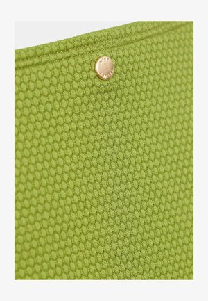 Teksturowana zielona tkanina z motywem plastra miodu, z okrągłym, złotym zapięciem na górnej krawędzi.