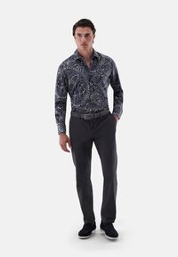 Herrenhemd mit navy Paisleymuster aus Baumwolle, kombiniert mit dunklen Hosen. Verfügt über einen klassischen Kragen und eine durchgehende Knopfleiste.