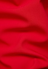 Red fabric with a smooth texture, featuring soft drapes and subtle variations in shade creating depth and dimension.