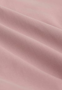 Tissu rose doux et lisse avec une texture côtelée fine et des plis délicats, mettant en valeur sa qualité de surface délicate et uniforme.