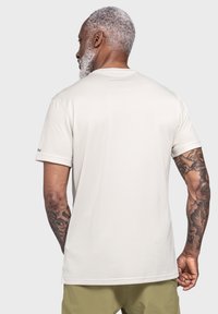 Light beige short-sleeve t-shirt with a round neck, smooth texture, subtle branding on the sleeve, and a relaxed fit.