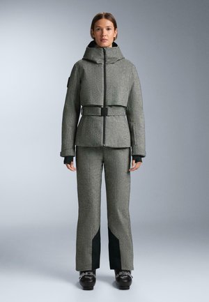 Giacca grigia con motivo, colletto alto, vita segnato da una cintura e pantaloni grigi abbinati con accenti verde scuro e tessuto strutturato.