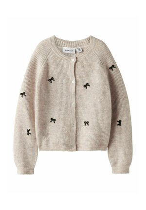 Cardigan tricoté beige clair avec des broderies en ruban noir, col rond et fermeture à boutons. Texture douce avec des détails côtelés.