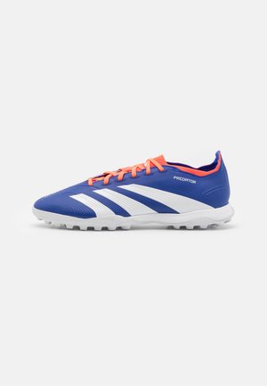 Scarpa da calcio sintetica blu con strisce bianche, lacci arancioni e tomaia testurizzata. Progettata per garantire trazione su superfici erbose.