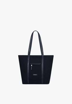 Sac fourre-tout noir avec longues poignées, poche zippée à l'avant, et étiquette de marque métallique rectangulaire centrée sous la poche, sur fond blanc.