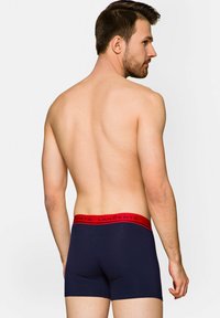 Granatowe bokserki z czerwonym ściągaczem, na którym widnieje napis "LANÇERTO". Materiał wydaje się gładki, a krój jest dopasowany.