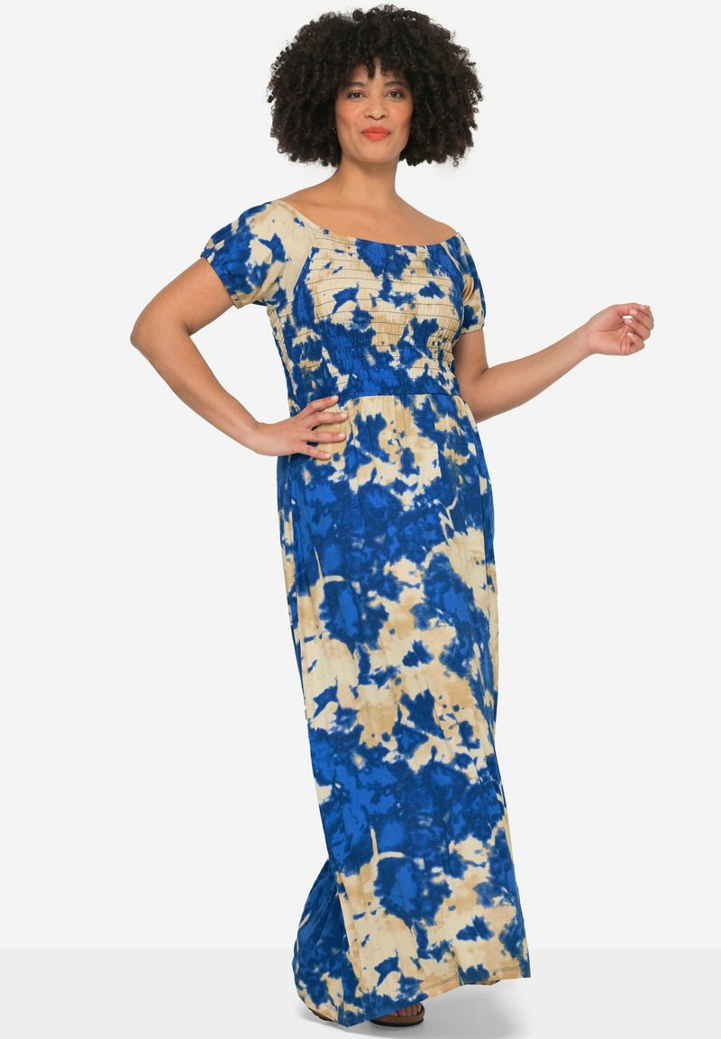 Maxikleid im blauen und beigen Batikmuster, mit quadratischem Ausschnitt, kurzen Ärmeln und gerafftem Oberteil. Lange, flatternde Silhouette.