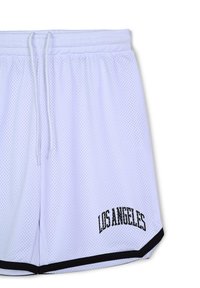 Pantaloni corti sportivi bianchi in rete con un logo nero "LOS ANGELES" sulla gamba sinistra e rifiniture nere all'orlo. Presentano una vita elastica e un cordino.