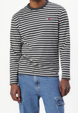 Langärmeliges Oberteil mit schwarzen und weißen horizontalen Streifen, rundem Halsausschnitt und kleinem roten und weißen Logo auf der Brust. Baumwollmischgewebe.