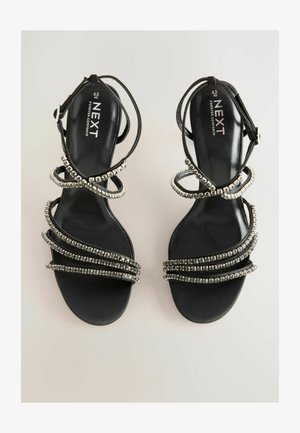 Czarne sandały na obcasie z wieloma błyszczącymi, srebrnymi ozdobami, z cienkimi paskami i wyściełaną wkładką. Rozmiar 6.5/40.