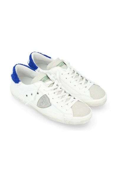 Sneakers bianche con accenti grigi e blu, materiale testurizzato, punta rotonda, suola piatta, con un'etichetta logo verde e lacci bianchi.