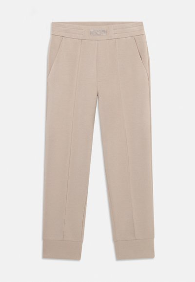 Beige Sweatpants aus weichem Stoff, mit einem Bund aus strukturiertem Material, seitlichen Taschen und schmal zulaufenden Bündchen an den Knöcheln.